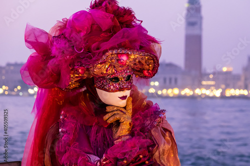 Venice, Italy - February 18, 2020: An unidentified woman in a carnival costume in front of Piazza San Marco, attends at the Carnival of Venice.