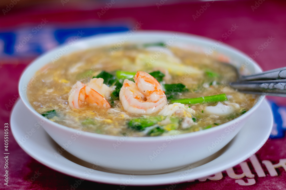 Thai noodle with shrimp in gravy, Rad Na with Mixed Seafood on table Street food in Thailand
