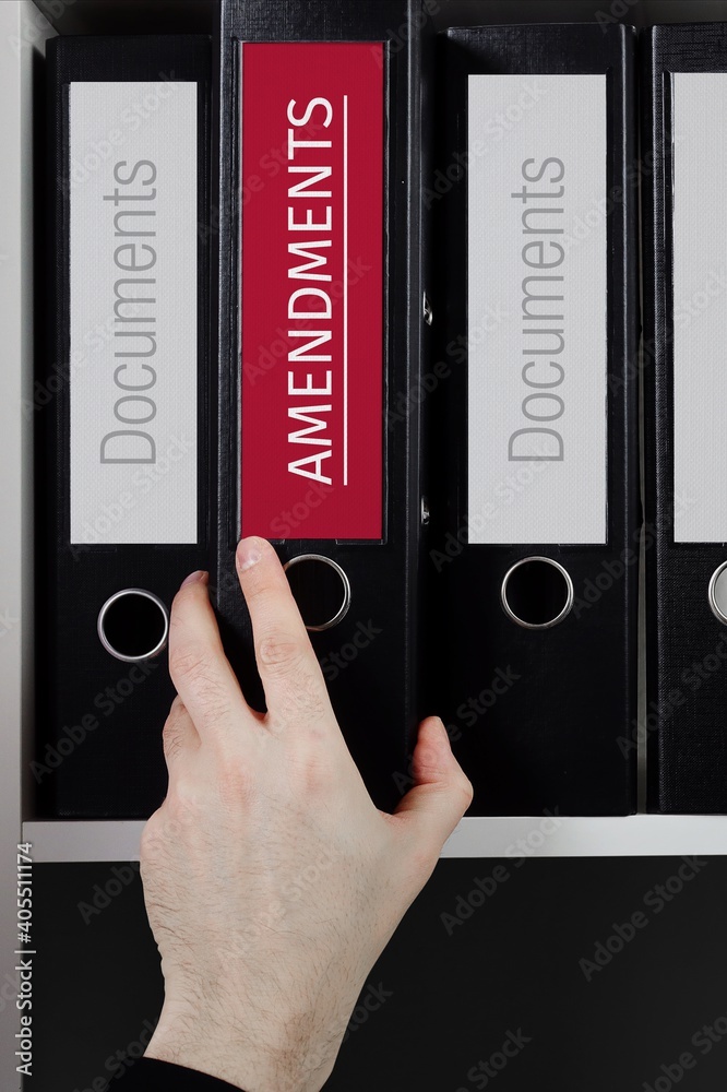 Amendments. Folder with label on the shelf of a lawyer. Red label with text in focus. Amendments. Folder with label on the shelf of a lawyer. Red label with text in focus.