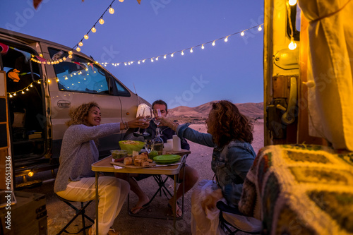 Group of cheerful happy and free people friends celebrate together toasting in outdoor adventure van vehicle travel vacation - enjoy free lifestyle adult man and women in friendship © simona