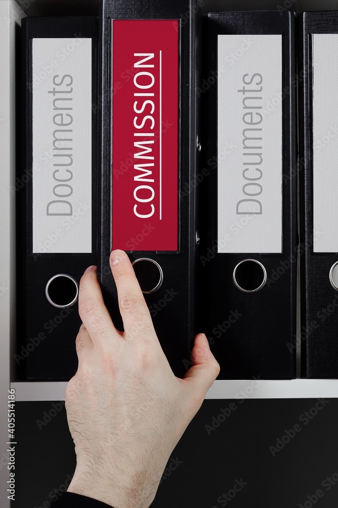 Commission. Folder with label on the shelf of a lawyer. Red label with text in focus.