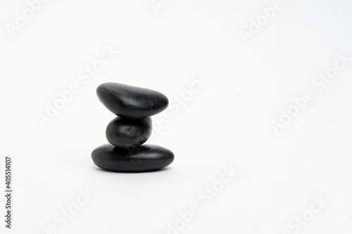 Black stone stack isolated on white background, group of  pebbles in tower, harmony and balance
