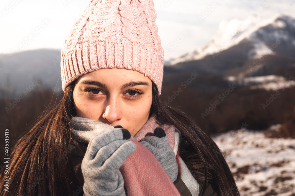 Young woman portrait on a winter landscape well wrapped up for cold Young woman portrait on a winter landscape well wrapped up for cold