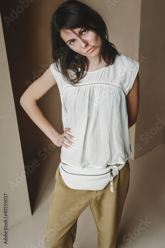 Leather Zipper Belt Pouch, Sling Crossbody Bag Women.  A beautiful young brunette woman is wearing a white blouse and a white leather waist bag. photo