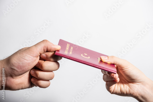 A Turkish red passport. woman gives Turkish passport to man.