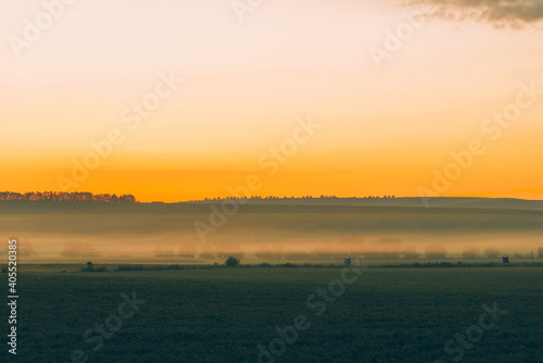 Beautiful morning landscape before sunrise in rural space with fog.
