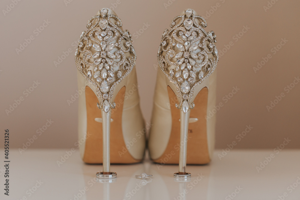 Amazing bridal shoes with diamonds and wedding rings setup. 