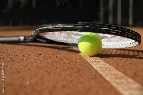 Tennis ball and racket on clay court, closeup © New Africa