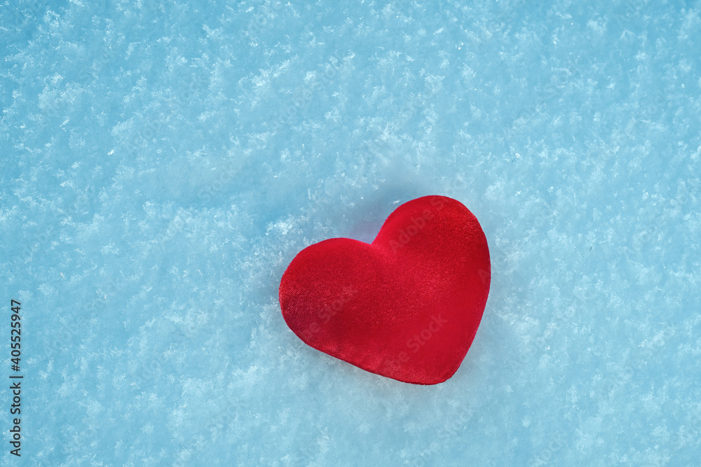 Fototapeta premium A red hot heart lies on the cold snow.