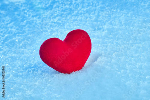 A red hot heart lies on the cold snow.