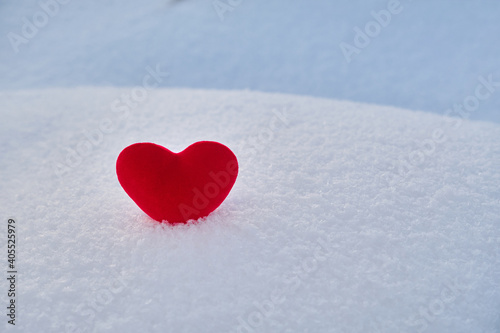 A red hot heart lies on the cold snow.