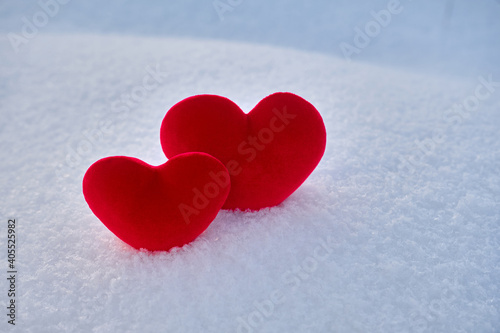 Two red hot hearts lies on the cold snow