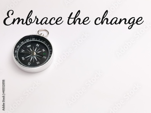 Top view text Embrace the change with compass isolated on white background.Motivational quote.