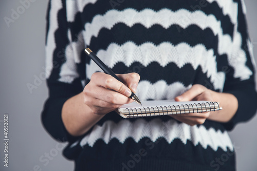 woman holding pen and notebook