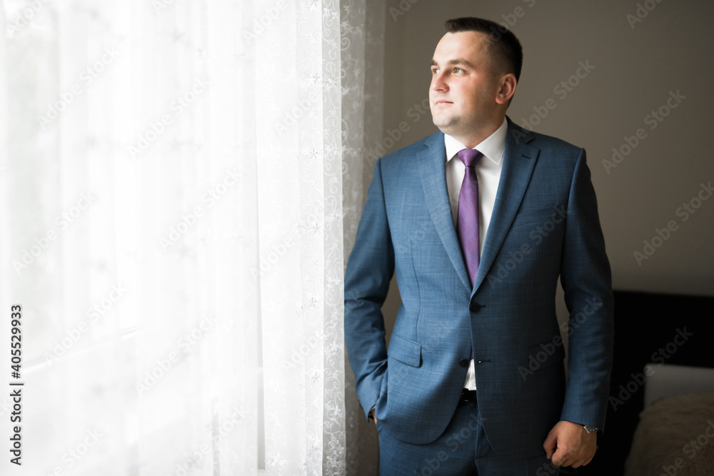 Grooms morning preparation. Handsome man getting dressed and preparing for the wedding Grooms morning preparation. Handsome man getting dressed and preparing for the wedding