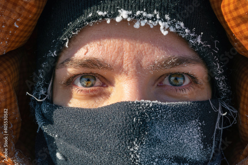 Extremely cold weather. Portrait of middle age European woman with face covered with snow frost.