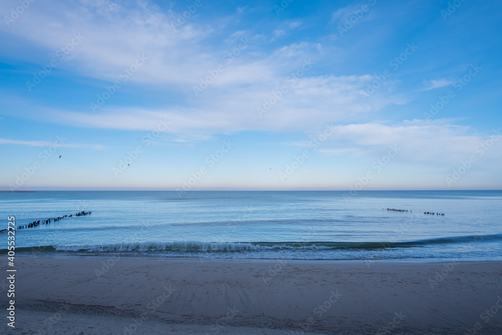 calm blue baltic sea against a blue sky with white cirrus clouds and an empty sandy beach, the city of Pionersky, Kaliningrad region calm blue baltic sea against a blue sky with white cirrus clouds and an empty sandy beach, the city of Pionersky, Kaliningrad region