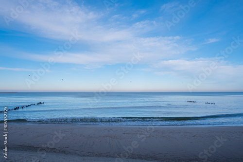 calm blue baltic sea against a blue sky with white cirrus clouds and an empty sandy beach  the city of Pionersky  Kaliningrad region