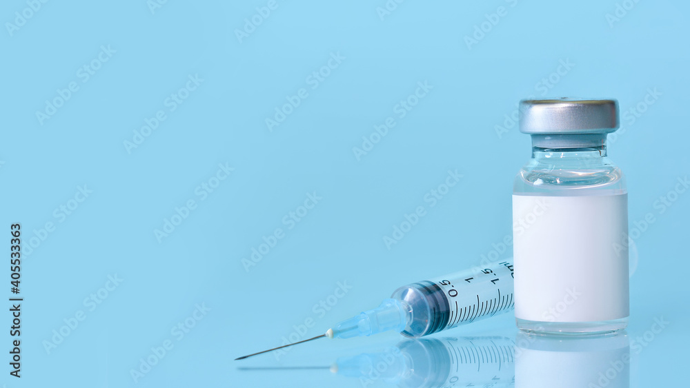 Vaccine in a bottle with a syringe on a blue background.The concept of medicine, healthcare and science.Coronavirus vaccine.Copy space for text.Banner Vaccine in a bottle with a syringe on a blue background.The concept of medicine, healthcare and science.Coronavirus vaccine.Copy space for text.Banner