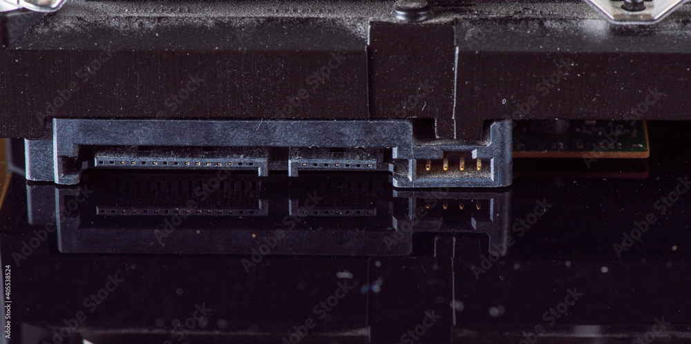 Component parts of a disassembled hard drive, close-up on a dark background. Component parts of a disassembled hard drive, close-up on a dark background.