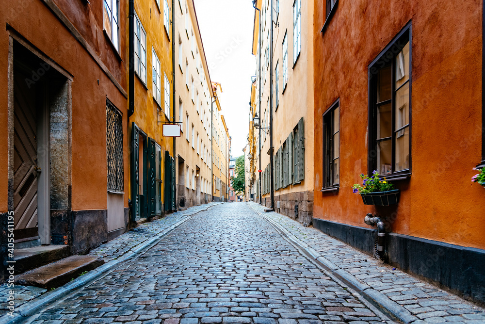 Beautiful old cobblestoned street amidst old colorful houses in Gamla Stan Quarter in Stockholm