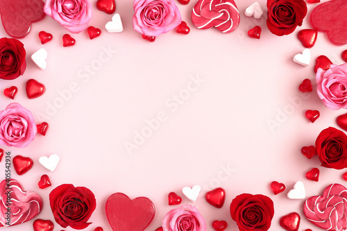 Valentine s Day background of pink and red roses and heart shaped candies. Space for text.
