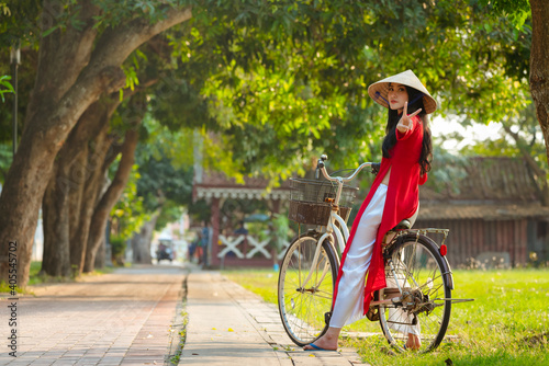 Portrait of Vietnamese girl traditional red dress,Beautiful young asian woman wearing Vietnam with bicycle