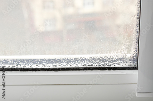 Drops of condensate on a white metal-plastic window