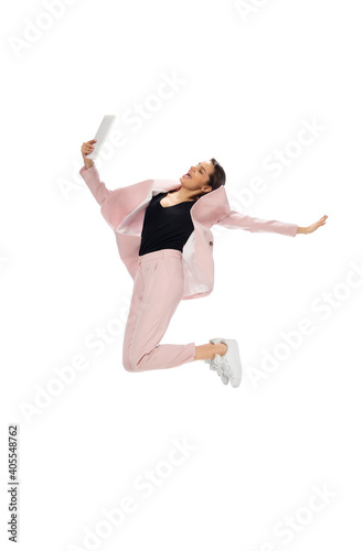 Flying. Happy young woman dancing in casual clothes or suit, remaking legendary moves and dances of celebrity from culture history. Isolated. Action, motion, fame concept. Creative occupation.