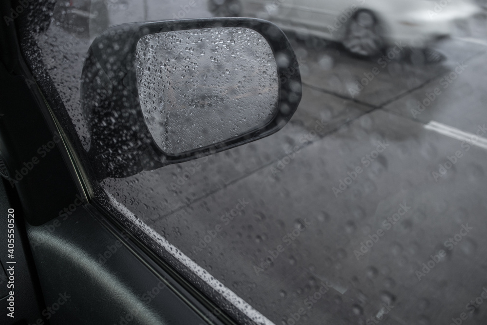 Rain drops on car side mirror.
