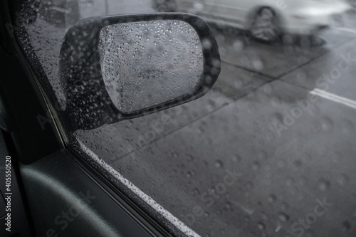 Rain drops on car side mirror.