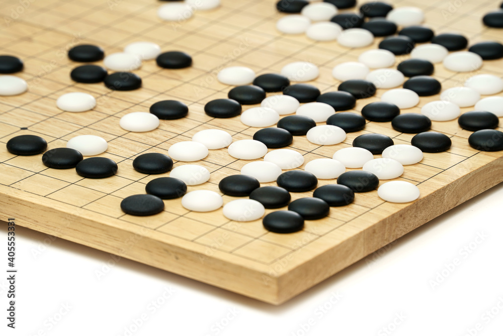 Black and White stones of GO (baduk, Weiqi) game on wooden board in competition tournament Black and White stones of GO (baduk, Weiqi) game on wooden board in competition tournament