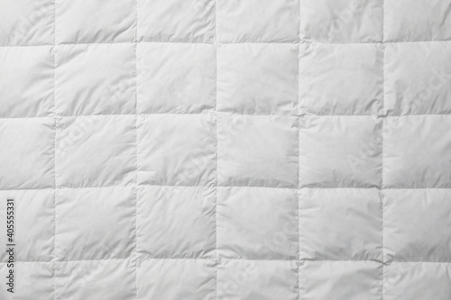 Soft quilted blanket as background, top view