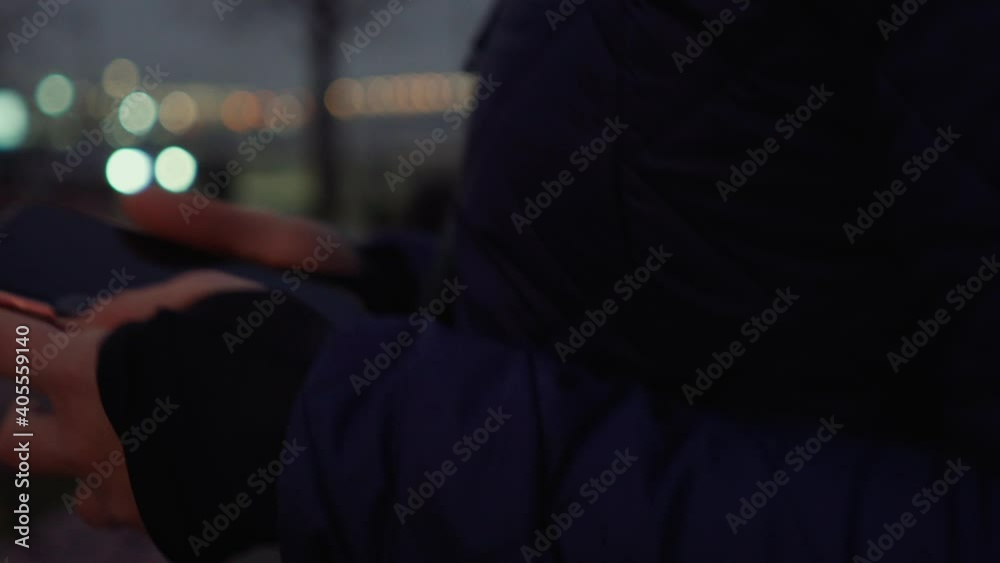 Crop woman using smartphone in evening in city. Crop female browsing modern mobile phone while walking on city street at night Crop woman using smartphone in evening in city. Crop female browsing modern mobile phone while walking on city street at night