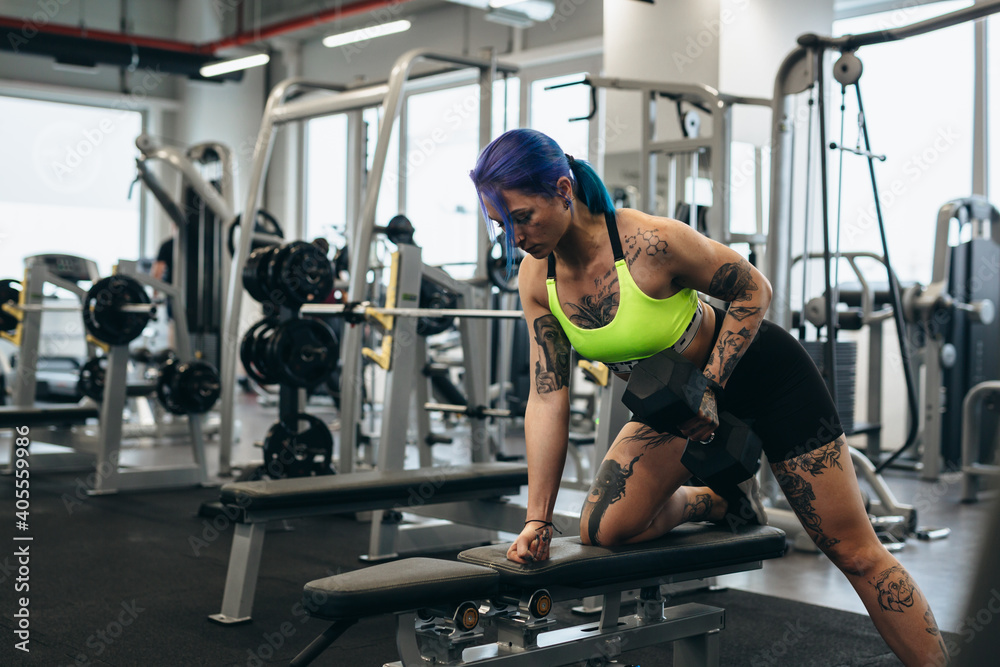 Fototapeta premium tattooed woman training in gym