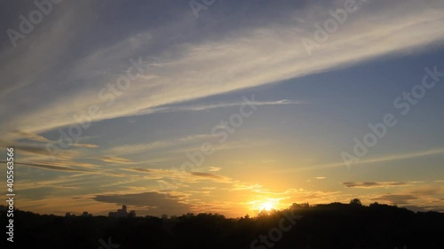 Time lapse of sunset with clouds and high rise building silhouettes on horizon 