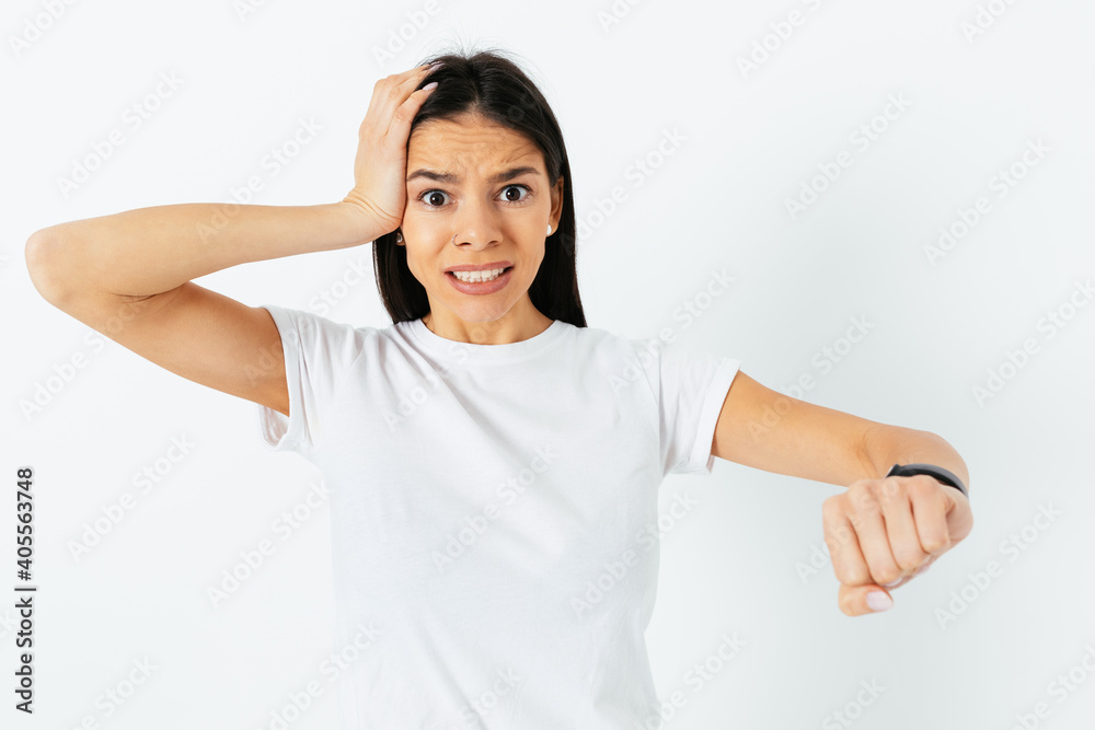 Portrait of a late young woman looking at her wristwatch Portrait of a late young woman looking at her wristwatch