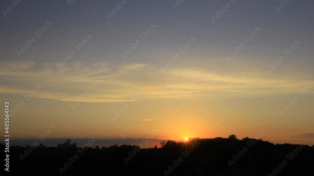 Time lapse of sunset with clouds and high rise building silhouettes on horizon Time lapse of sunset with clouds and high rise building silhouettes on horizon