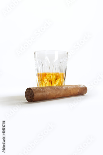 Closed up view of glass of whiskey with cigar on white back