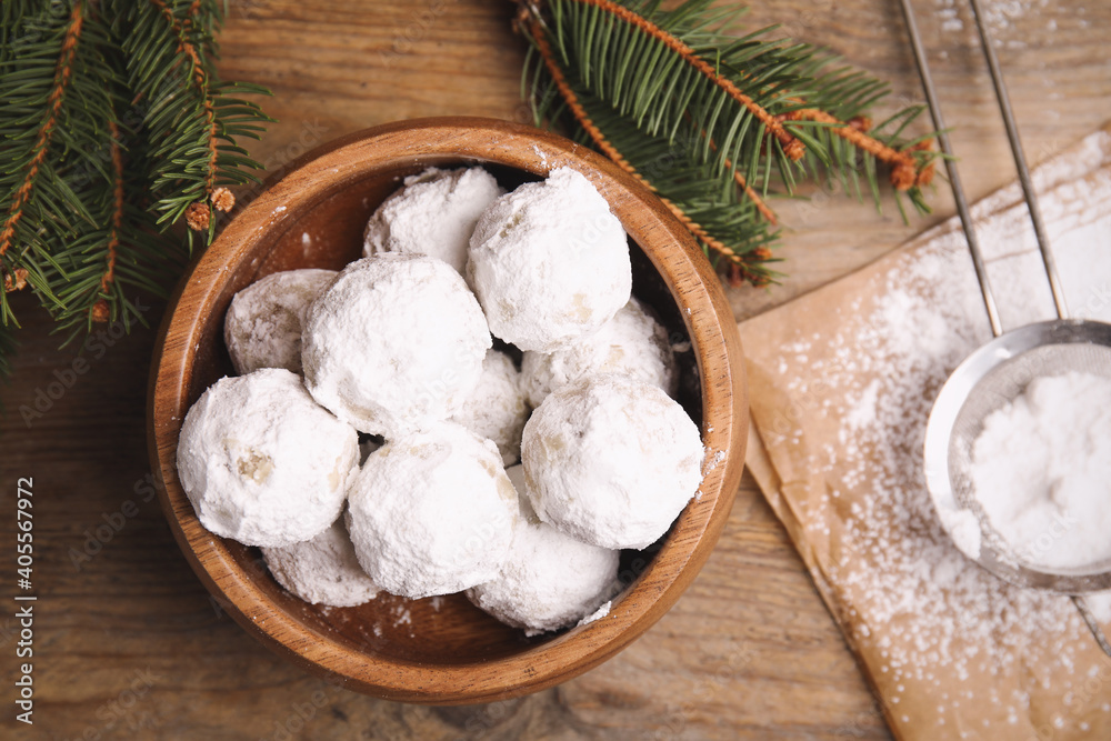 Tasty Christmas snowball cookies in bowl on wooden table, flat lay Tasty Christmas snowball cookies in bowl on wooden table, flat lay