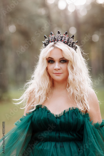 young beautiful blonde hair woman queen. Princess walks. autumn green forest mystic. Vintage medieval shiny crown. Long evening green dress. magic fantasy © Andriy Medvediuk