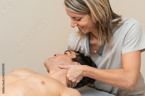 physiotherapist does session to man. cervical manipulation, trapezium stretch photo