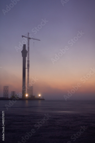 Crane at sunrise in the fog