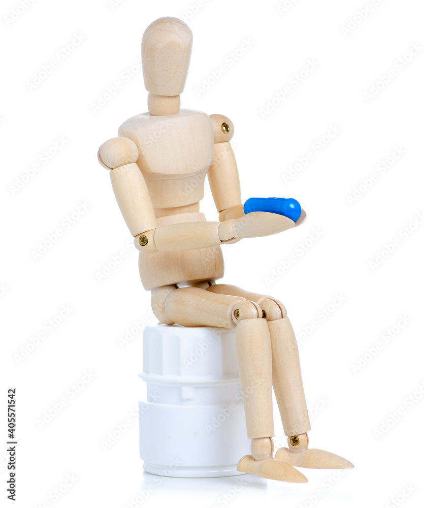 Wooden man with jar pills capsules on white background isolation Wooden man with jar pills capsules on white background isolation