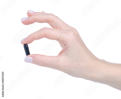 Black pill capsule in hand on white background isolation