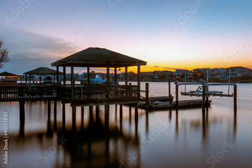 The sun is setting and sky is almost clear of clouds at these Private docks in the Banks Channel near the Intracoastal Waterway in Wrightsville Beach  North Carolina