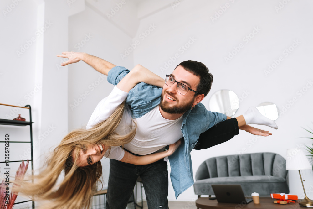 Young happy cheerful couple having fun in living room at home. Young happy cheerful couple having fun in living room at home.