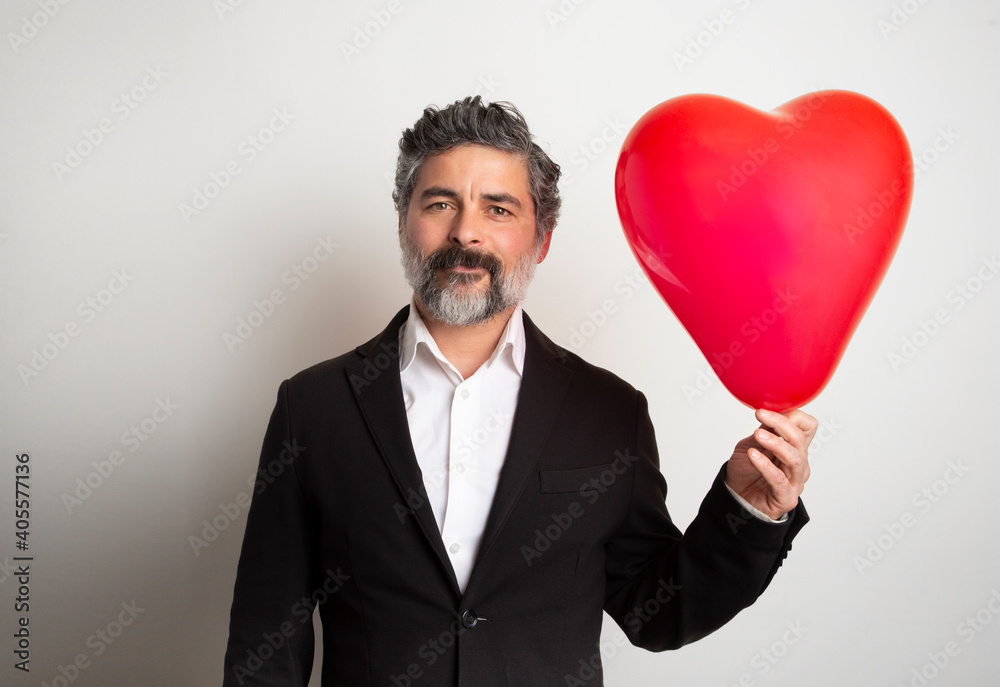 Love and valentines day man holding heart smiling cute and adorable isolated. Valentine man with red air ballon. Love and valentines day man holding heart smiling cute and adorable isolated. Valentine man with red air ballon.