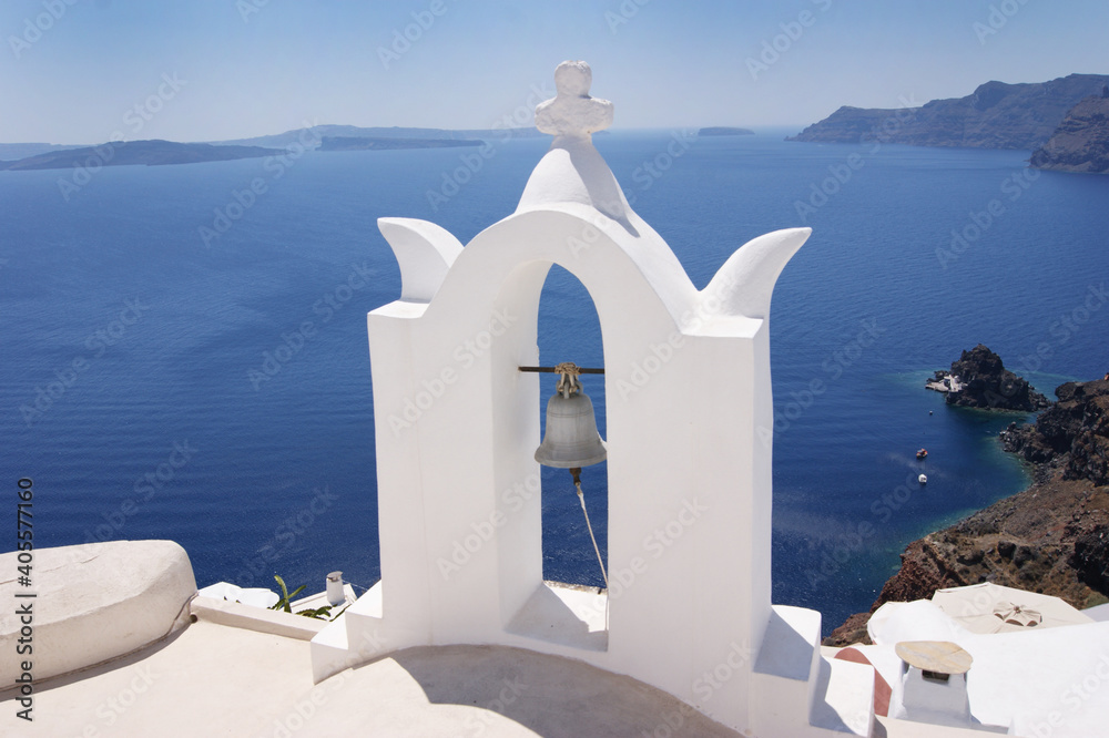 white bell tower on Santorini island in Greece. Famous tourustic view. Wallpaper. Traveling to beautiful places.