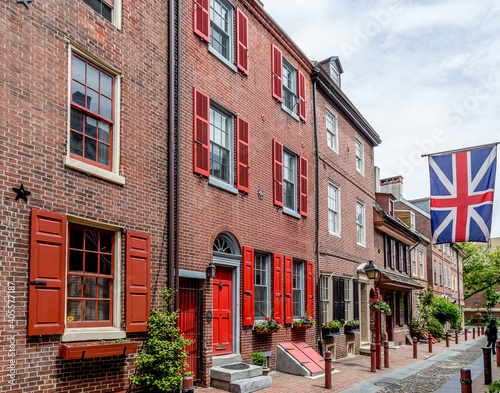 Philadelphia street scene in historical Elfreth's Alley section of the city. Showing colonial homes with British flag.